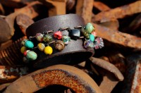 charm bracelet on a leather cuff